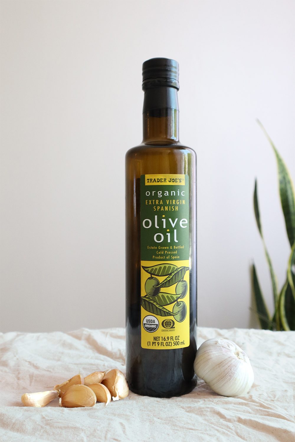 Bottle of olive oil with fresh garlic cloves and a whole bulb