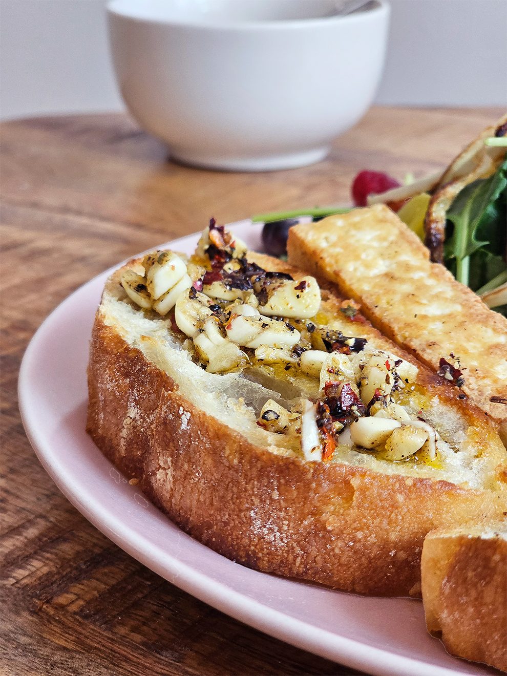 Garlic oil drizzled over toasted bread with a side salad