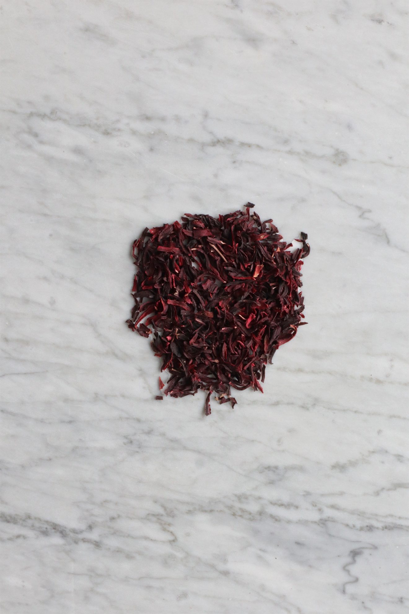 Dried hibiscus petals on a marble surface