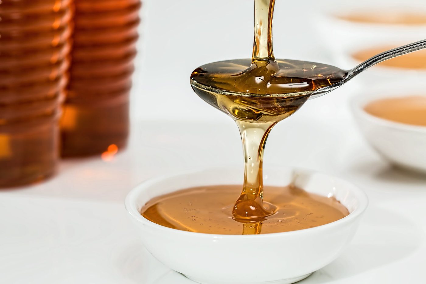 Honey being drizzled from a spoon into a bowl