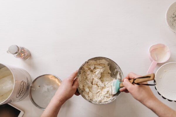 Hands mixing batter in a bowl